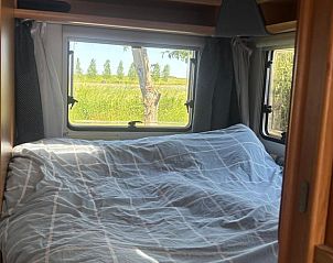 Gezellige slaapkamer in Vakantiehuis in Tull en 't Waal, Utrecht met uitzicht op de groene omgeving vanuit het raam.