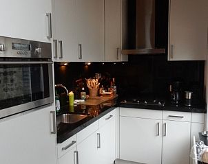 Moderne keuken in Achthoek 64, vakantiehuis in Scharendijke, Zeeland, met strakke witte kasten.