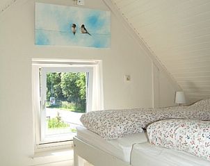 Lichte slaapkamer in Villa Lente, Scharendijke, met comfortabel bed en uitzicht op de natuur in Zeeland.