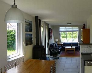 Gezellige woonkamer van Strand 97 in Scharendijke, Schouwen-Duiveland, met veel lichtinval en uitzicht op de groene omgeving.