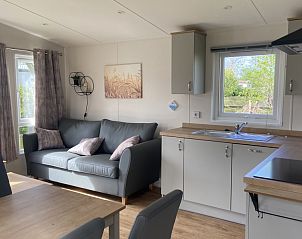 Gezellige woonkamer in chalet op Camping de Duinhoeve, Burgh-Haamstede, met veel natuurlijk licht en comfortabele zitruimte.
