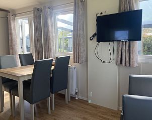 Eethoek in chalet op Camping de Duinhoeve, Burgh-Haamstede, met uitzicht op terras en tuin in Zeeland.