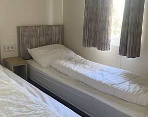 Slaapkamer met twee eenpersoonsbedden in chalet op Camping de Duinhoeve, Burgh-Haamstede, ideaal voor gezinnen.