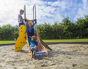 Jonge kinderen spelen op glijbaan in zandbak op Camping de Duinhoeve, Burgh-Haamstede, Zeeland.