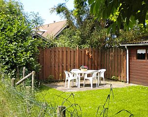 Priv tuin met zitplaats bij De Voorpost vakantiehuis in Burgh-Haamstede, voor ontspanning.