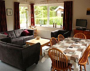 Gezellige woonkamer in VakantiewoningZeeland, Burgh-Haamstede, Schouwen-Duiveland, met ruime zithoek en eettafel voor een ontspannen verblijf.