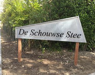 Ingang van Schouwse Stee 14, Westenschouwen, Schouwen-Duiveland, met bord en groene omgeving, ideaal voor vakanties.