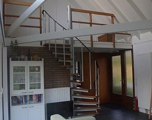 Interieur van De Parel in Burgh-Haamstede, met een stijlvolle wenteltrap naar de bovenverdieping.