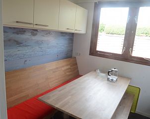 Eethoek in De Parel, Burgh-Haamstede, met houten tafel en uitzicht op de tuin.