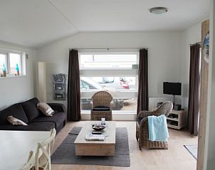 Gezellige woonkamer in chalet Boormossel, Renesse, Zeeland met comfortabele zitruimte en veel natuurlijk licht.