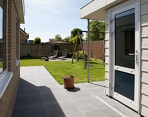 Ingang van de Tureluur bungalow in Renesse, met uitzicht op de groene tuin en terras in Zeeland.