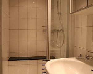 Moderne badkamer in de Tureluur vakantiehuis in Renesse, Schouwen-Duiveland, met douche en wastafel.