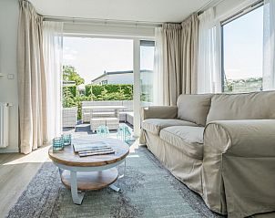 Gezellige woonkamer in Eureka Park Chalet 92, Schouwen-Duiveland, met comfortabele bank en toegang tot het terras.