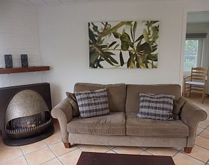 Gezellige zitkamer in Westhoek 14 bungalow, Renesse, met comfortabele bank en stijlvolle inrichting.