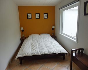 Hoofdslaapkamer van Westhoek 14 bungalow in Renesse, Zeeland, met tweepersoonsbed en zonnig raam.