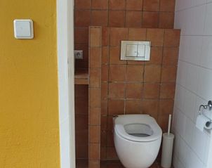 Toilet van Westhoek 14 bungalow in Renesse, Zeeland, met warme tegelafwerking.