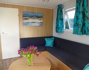 Gezellige woonkamer van Chalet Aqua in Kerkwerve, Zeeland met comfortabele bank en decoratieve accenten.