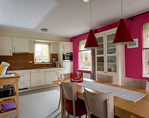 Keuken en eetruimte in Arcadia vakantiehuis in Zonnemaire, Schouwen-Duiveland met stijlvolle rode lampen.