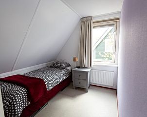 Slaapkamer met eenpersoonsbed in Arcadia vakantiehuis in Zonnemaire, Schouwen-Duiveland met uitzicht op de tuin.