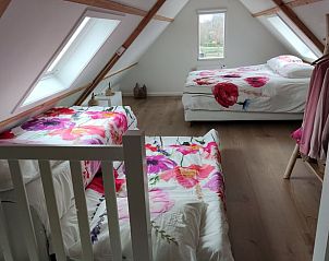 Zolderkamer met drie bedden in Vakantiehuis in Noordgouwe, perfect voor een familieverblijf in Zeeland.