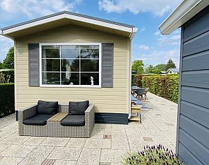 Buitenzijde van VZ539 Vakantiechalet Ouwerkerk met terras, omgeven door groen in Zeeland.