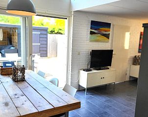 Eetruimte in De Schurveling vakantiehuis, Ouddorp met uitzicht op de tuin en veel natuurlijk licht.