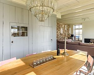 Eetkamer met houten tafel en kroonluchter in Hoeve Plantlust, vakantiehuis Oostkapelle.