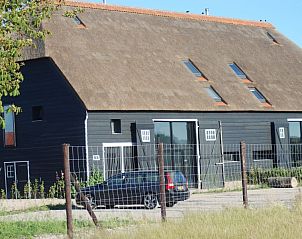 Voorzijde van Hoeve Plantlust in Oostkapelle, Walcheren, vakantiehuis met rieten dak en moderne uitstraling.