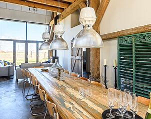 Stijlvolle eetruimte van Hoeve Plantlust in Oostkapelle, Walcheren, met lange houten tafel en moderne inrichting.