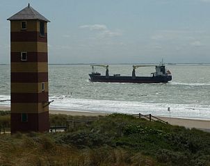 Vuurtoren en schip nabij Dishoek, Walcheren met Van de Zeeuwse Stromen vakantiehuis, Zeeland.