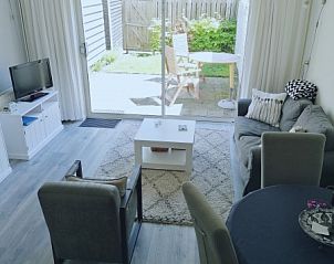 Lichte woonkamer van Vakantiewoning Domburg, vakantiehuis in Zeeland met comfortabele zithoek en uitzicht op terras.