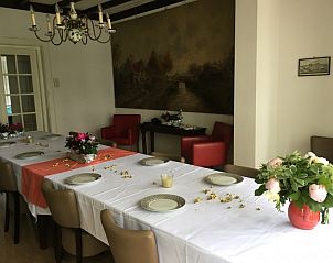 Ruime eetkamer in Villa Vacuna, vakantiehuis in Domburg, Walcheren met kunst aan de muur.