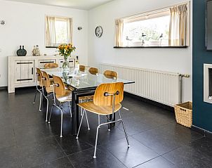 Eetkamer in Westduin 19 vakantiehuis, Vlissingen, Walcheren, met glazen tafel en houten stoelen.