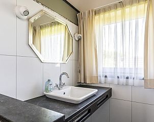 Wastafel met spiegel in Westduin 19 vakantiehuis, Vlissingen, Walcheren, met natuurlijk licht.