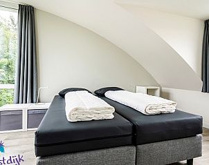 Slaapkamer met tweepersoonsbed in Galgewei 16, vakantiehuis Vlissingen, Walcheren, Zeeland met uitzicht op groen.