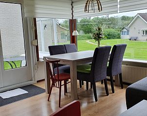 Lichte eetkamer in DE ZON IN ZEELAND vakantiehuis, Vlissingen, met uitzicht op tuin.