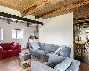 Comfortabele zithoek in Mariekerke vakantiehuis, Meliskerke, Walcheren, met moderne meubels en houten details.