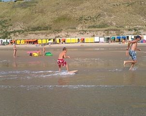 Gezin geniet van strandactiviteiten nabij Vakantieverblijf Uit en Thuis, Zeeland.
