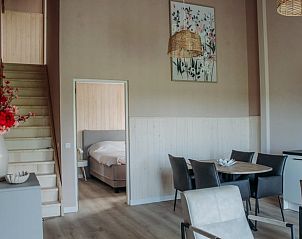 Moderne woonkamer van Vakantiehuis in Ritthem, Walcheren, met eetgedeelte en trap.