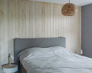 Comfortabele slaapkamer met houten wand in Vakantiehuis in Ritthem, Walcheren.