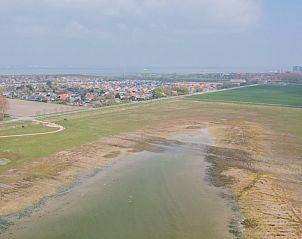 Uitzicht op de natuurlijke omgeving rondom Mer du Nord, strandhuis in Breskens, Zeeuws-Vlaanderen, met weidse velden en waterpartijen.