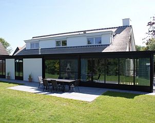 Achtertuin van Mer du Nord, een strandhuis in Breskens, Zeeuws-Vlaanderen, met een ruim terras en groene omgeving in Zeeland.