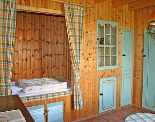 Knusse binnenruimte in De Bedstee, Schoondijke met houten afwerking en gezellige bedstee.