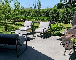 Zonnig terras met zitplek bij Vakantiehuisje in Ovezande, Zeeland.