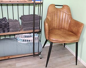 Comfortabele stoel en opbergruimte in Huisje in Ovezande, Zuid-Beveland, voor een ontspannen verblijf.