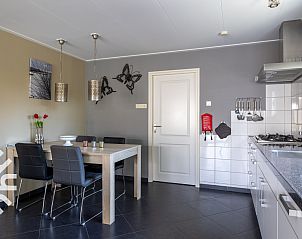 Ruime tuin van vakantiehuis ZE207 in Oud Sabbinge, met zitgelegenheid en bloeiende planten.