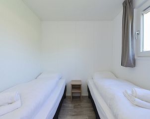 Twee comfortabele bedden in slaapkamer van Vakantiehuis Hart van Zeeland, Heinkenszand.