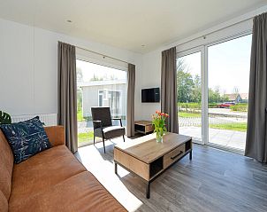 Lichte zithoek met uitzicht op de tuin in Vakantiehuis Hart van Zeeland, Zuid-Beveland.