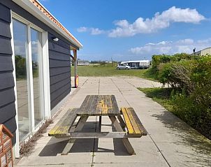 Zonnig terras bij Vakantiehuis in BORSSELE, Borssele, Zeeland, met picknicktafel en uitzicht op de omliggende natuur.