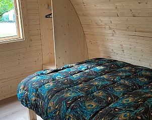 Knusse slaapkamer in vakantiehuisje in Borssele, Zuid-Beveland, met uitzicht op de natuurlijke omgeving.